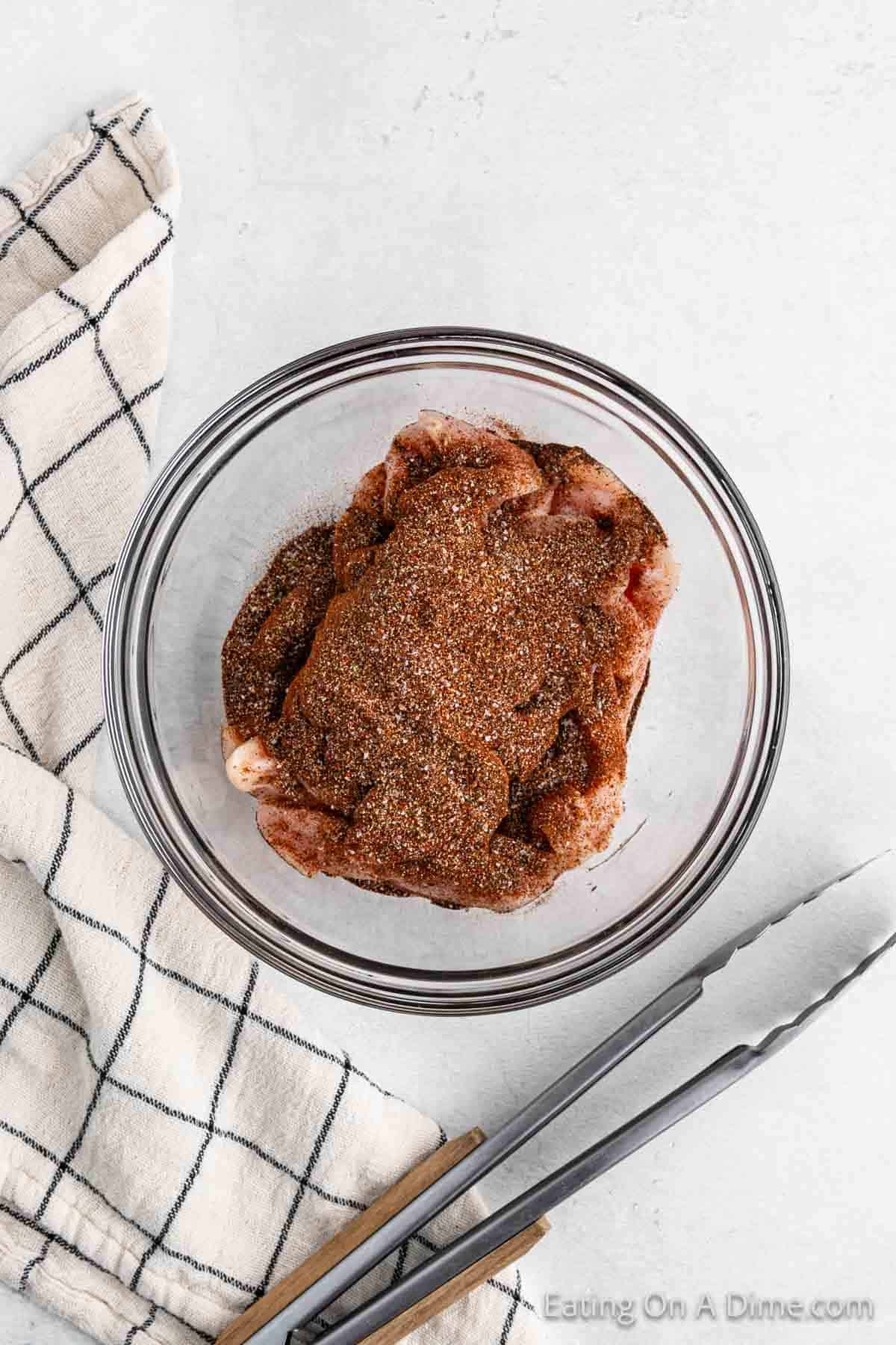 Coating chicken with the seasoning blend in a bowl