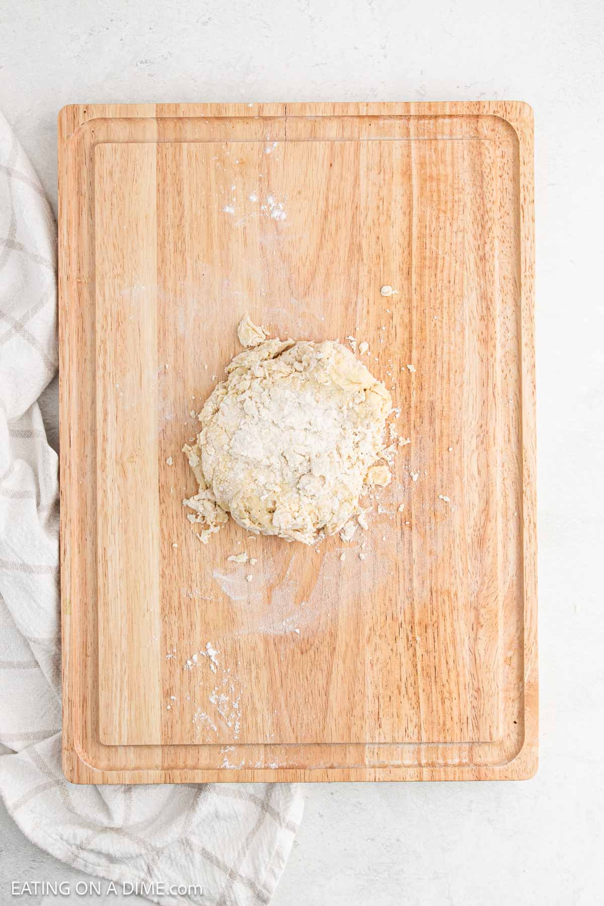 Dough topped with flour on a cutting board